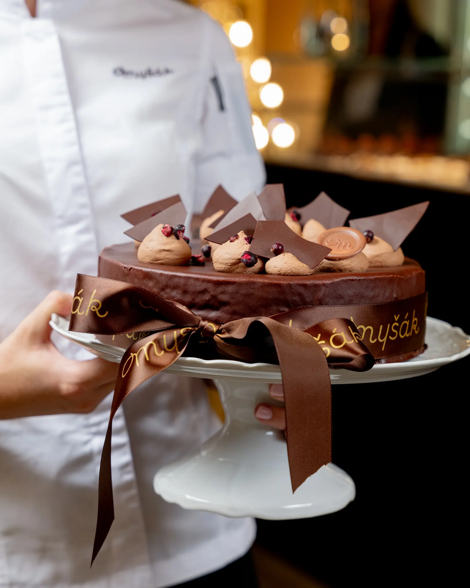 Chocolate cake from Myšák pastry shop on a serving stand.